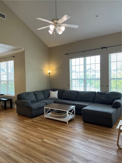 Living room with lofted ceiling, ceiling fan, ligh
