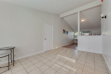 Empty room with light tile patterned floors and baseboards