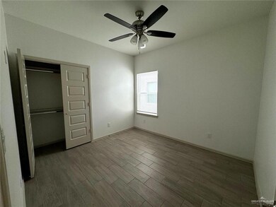 Unfurnished bedroom with a ceiling fan, wood finished floors, baseboards, and a closet