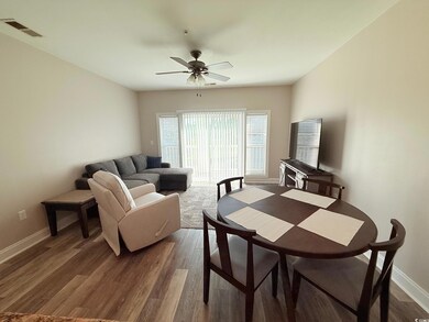 Living area featuring baseboards, a ceiling fan, visible vents, and dark wood finished floors
