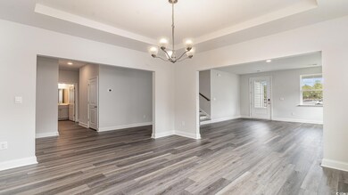Unfurnished room with stairs, a tray ceiling, and 