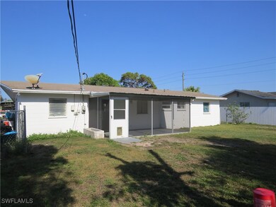 Rear view of house featuring a yard, concrete bloc