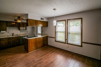 Kitchen featuring ceiling fan, dark hardwood / woo