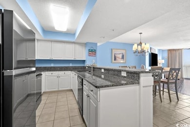 Kitchen featuring a peninsula, white cabinetry, an