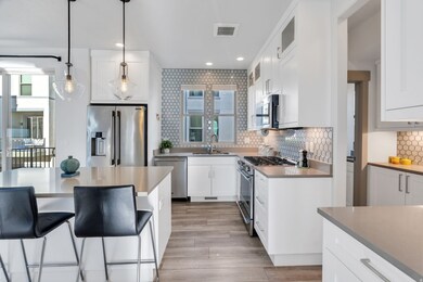 Kitchen featuring glass insert cabinets, white cabinets, appliances with stainless steel finishes, backsplash, and recessed lighting