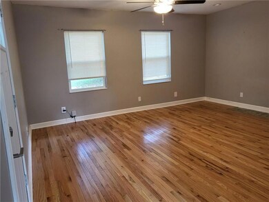 Empty room featuring hardwood / wood-style flooring and ceiling fan
