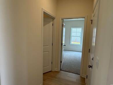 Hall with light wood-style floors and baseboards
