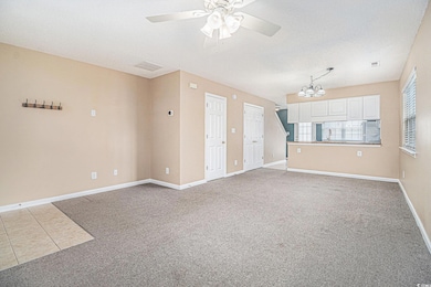 Carpeted spare room with ceiling fan, a chandelier, and a textured ceiling