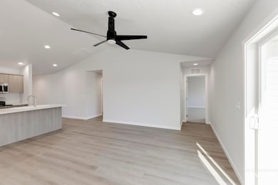 Unfurnished living room with lofted ceiling, light wood finished floors, recessed lighting, and a ceiling fan
