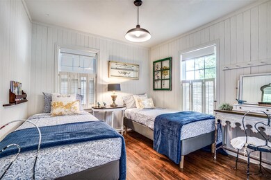 Bedroom with wood walls, crown molding, and dark w
