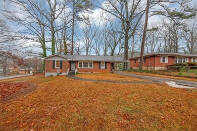 Ranch-style home with asphalt driveway, brick siding, a front lawn, an attached carport, and crawl space