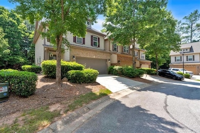 Multi unit property with brick siding, a garage, and driveway