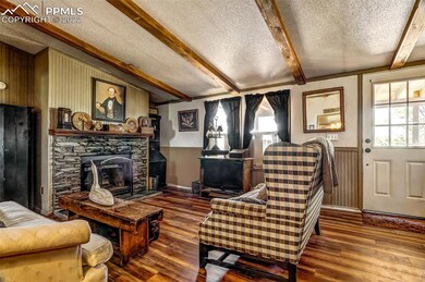 LIVING ROOM WITH FAUX BEAMS AND WOOD BURNING FIREP