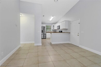 Kitchen featuring white cabinets, light tile patterned floors, and appliances with stainless steel finishes