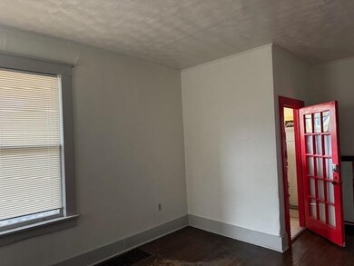 Empty room featuring dark wood-type flooring and a