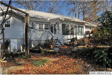 Back of home has open deck with steps down to a la
