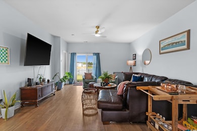 Living room with ceiling fan and hardwood / wood-style floors