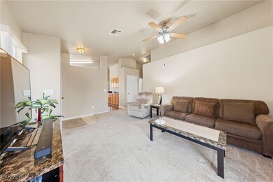Carpeted living room with visible vents, baseboard