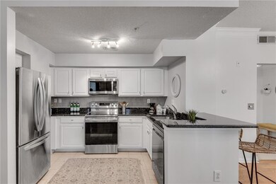 The kitchen is well-appointed with stainless steel appliances, granite counters, a cozy breakfast bar, and plenty of counter space—perfect for cooking, dining, and entertaining.