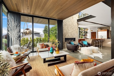 Warm and inviting living room features floor to ceiling windows and cedar lined ceiling. Stacking sliding glass doors open to a view patio