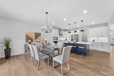 Dining room featuring a chandelier, recessed lighting, and light wood-style flooring