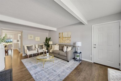 Living area featuring beamed ceiling, dark wood-type flooring, and a textured ceiling