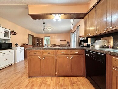 Kitchen featuring a textured ceiling, light hardwo