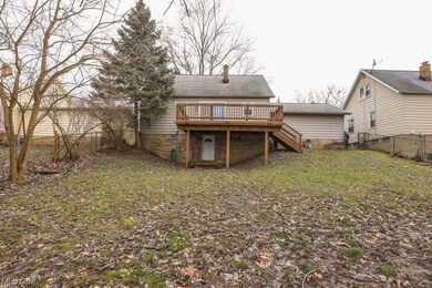 Back of property featuring a lawn and a wooden deck