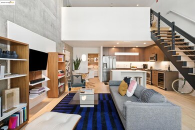 Living room featuring a high ceiling, light wood finished floors, wine cooler, and stairway