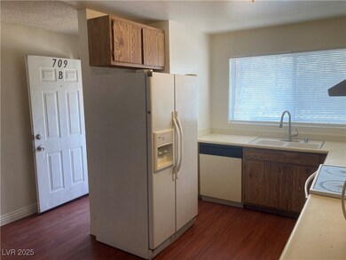 Kitchen with white appliances, dark wood-style flo