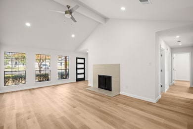 Unfurnished living room with recessed lighting, beamed ceiling, a tiled fireplace, light wood-style floors, and high vaulted ceiling