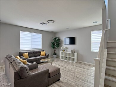 Living room with visible vents, light wood-style f
