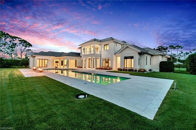 Back house at dusk with a patio and a lawn