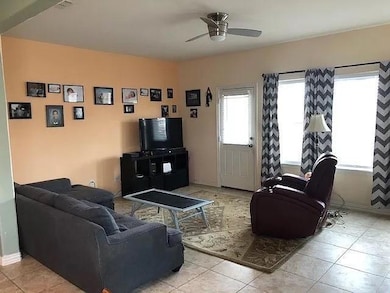 Living room with a ceiling fan, baseboards, and l