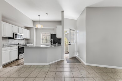 Kitchen with light stone countertops, light tile p