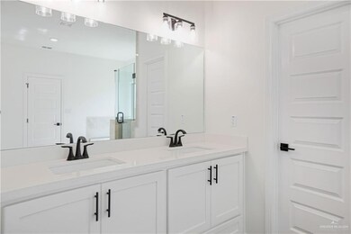 Full bathroom featuring double vanity, a sink, and a stall shower