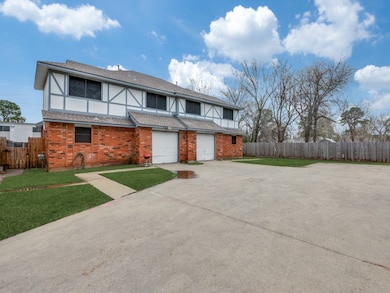 Tudor home featuring concrete driveway, an attached garage, a shingled roof, and brick siding