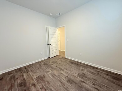 Empty room with dark wood finished floors, baseboa