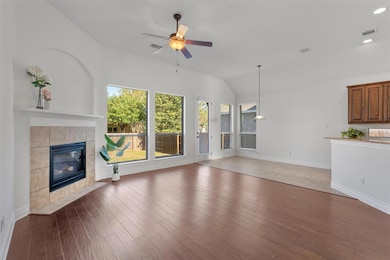 Unfurnished living room with a tile fireplace, ceiling fan, light wood finished floors, lofted ceiling, and recessed lighting