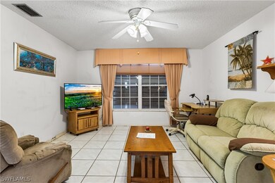 Living room featuring ceiling fan, a textured ceil