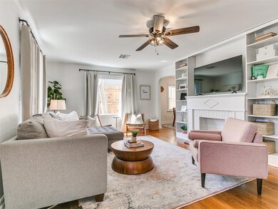 Living room with a brick fireplace, ceiling fan, a