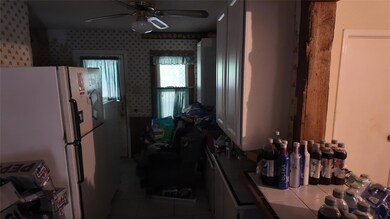Kitchen with white cabinetry, white fridge, tile c