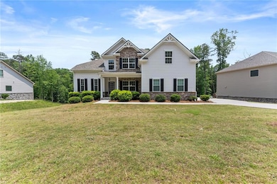 View of front of home featuring a front lawn and stone siding
