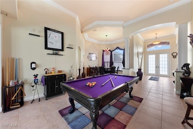 Game room with ornamental molding, pool table, french doors, and light tile patterned flooring