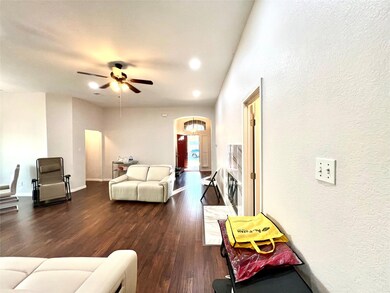 Living room featuring ceiling fan and dark wood-type flooring