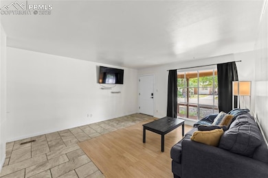 Living room with light tile patterned flooring and baseboards