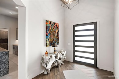 Entrance foyer with light wood finished floors, recessed lighting, and a chandelier