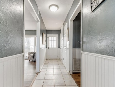 Hall featuring a wainscoted wall, visible vents, a