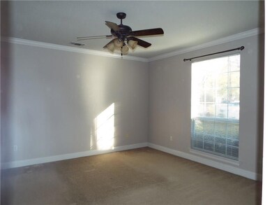 Master bedroom with carpet and crown molding.