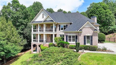 Neoclassical / greek revival house featuring a balcony, brick siding, a chimney, and a porch